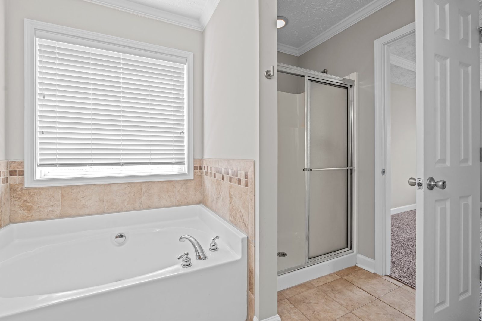 Primary bathroom with a garden tub and a glass-door walk-in shower