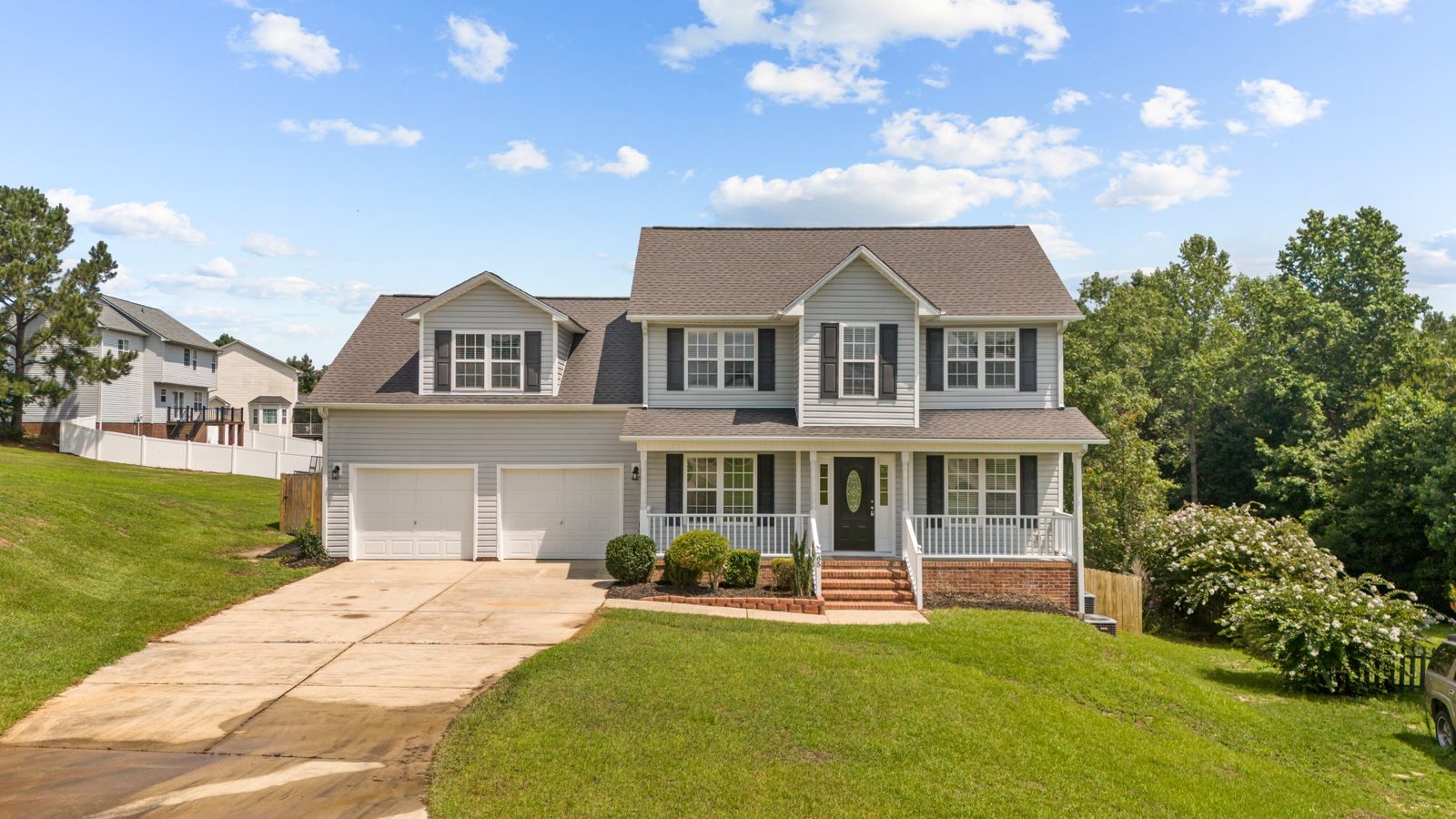 Two-story home with a new shingle roof, front porch and green lawn