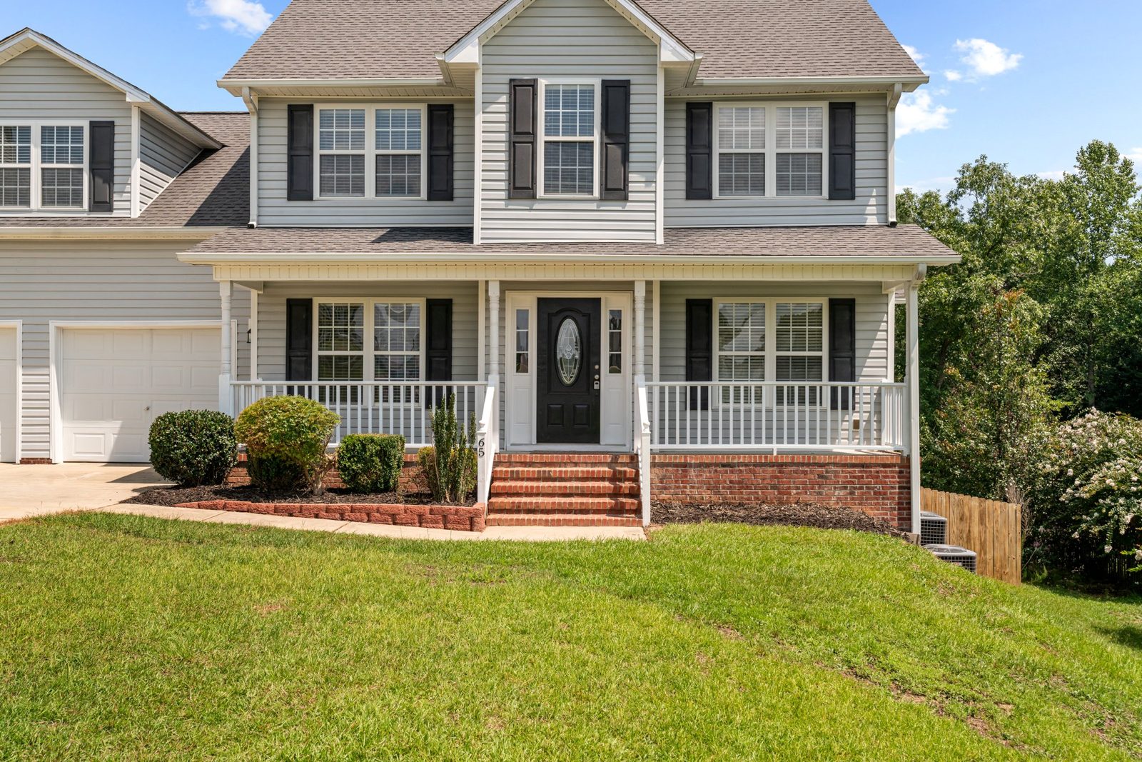 Two-story home with a covered front porch, gray siding and shingle roof