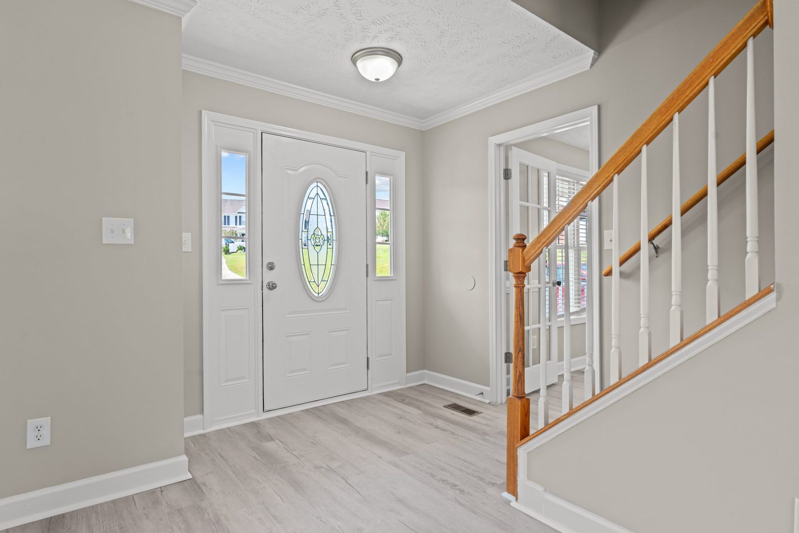 Entry with new plank flooring, front door with sidelights and staircase