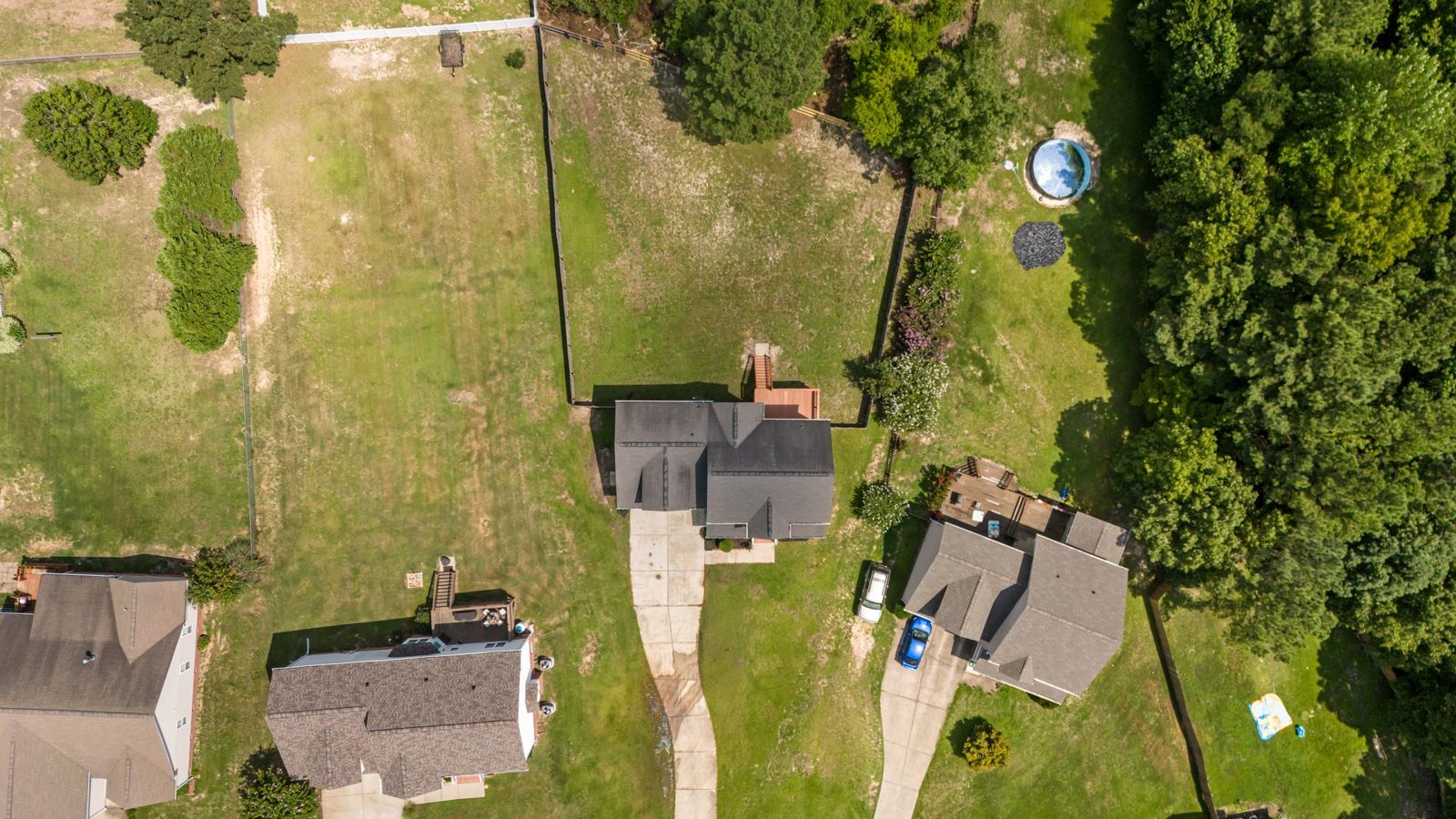 Overhead drone view of a home with a finished shingle roof and backyard