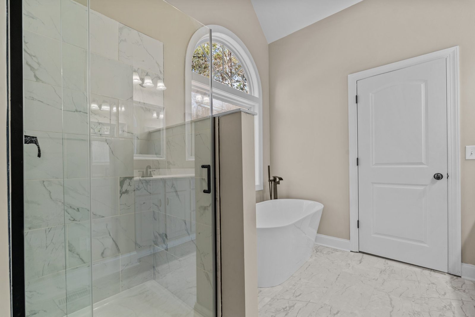 Primary bathroom with a tiled walk-in shower beside a freestanding tub