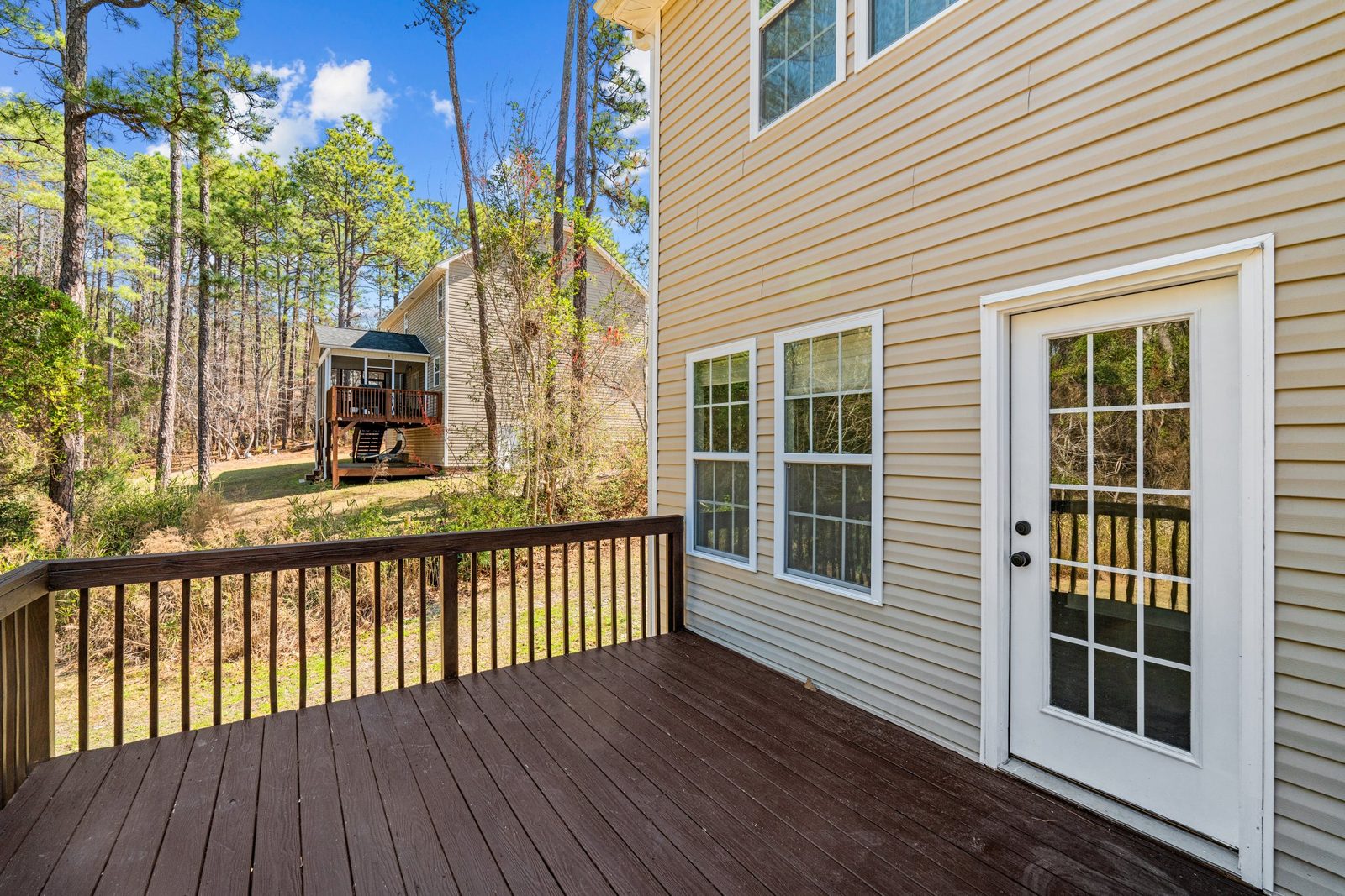 Rear deck with a new door on a home with tan siding