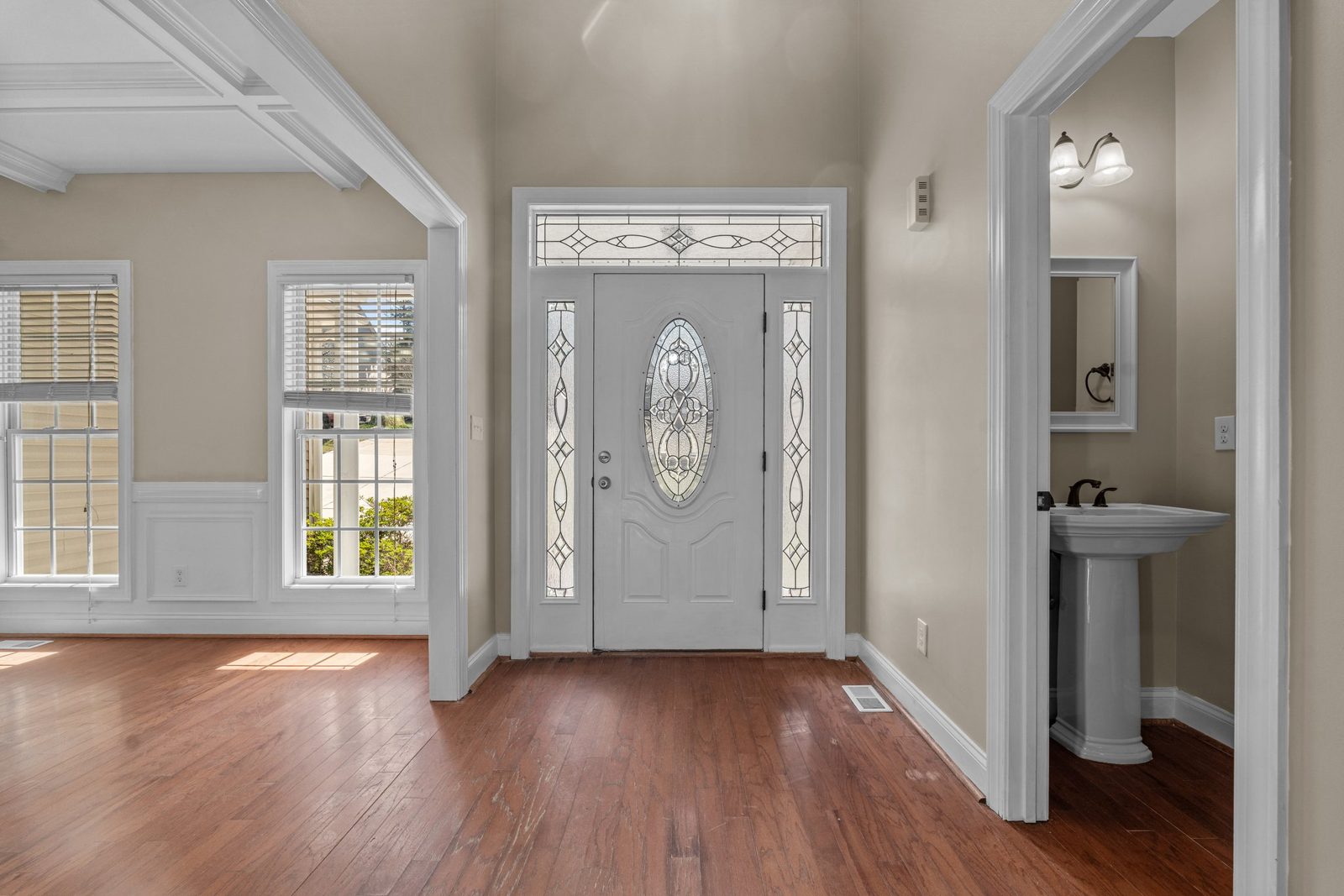 Entry with refinished wood floors, front door and half bath