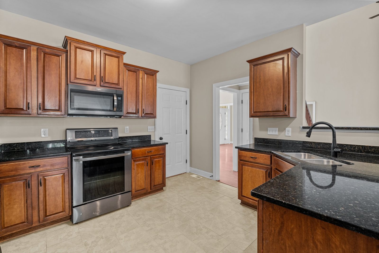 Kitchen with wood cabinets, dark counters and a stainless range