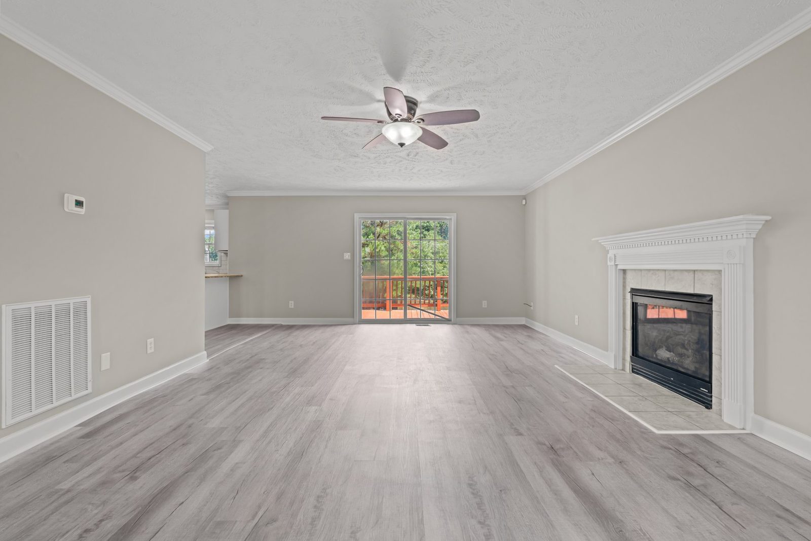 Renovated living room with new wood-look plank flooring, fresh paint and white trim around the gas fireplace