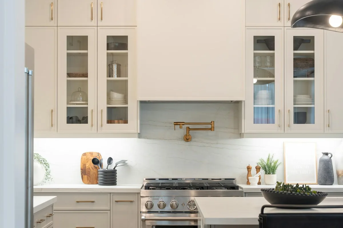 Kitchen with a white island, range wall and pendant light