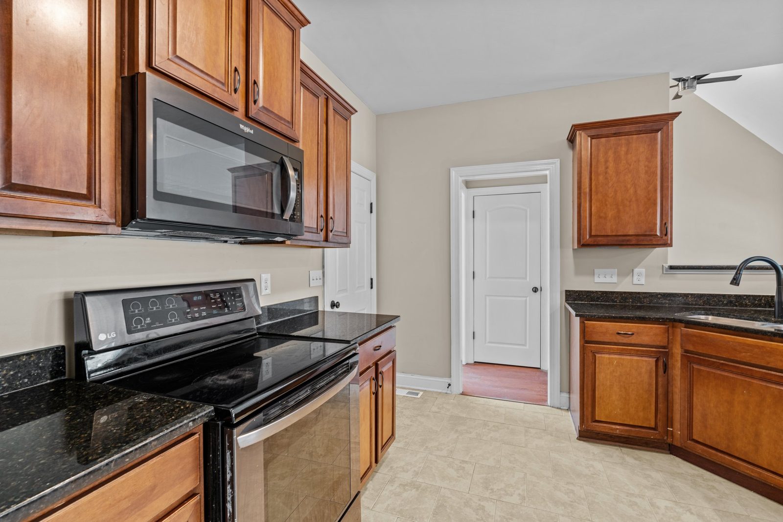 Kitchen with replaced cabinets and dark stone counters